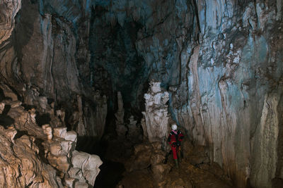 Rear view of person standing in cave