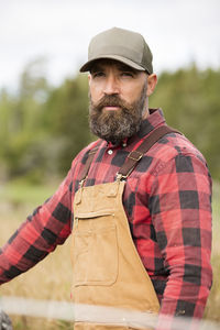 Male farmer in plaid shirt standing outdoors