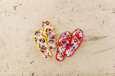 High angle view of multi colored slippers on sand