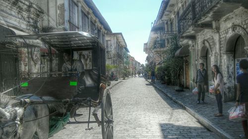 People on street amidst buildings in city