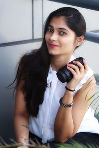 Portrait of a smiling young woman using smart phone