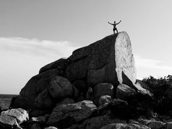 Low angle view of people standing on rock