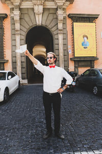 Full length portrait of young man standing in city