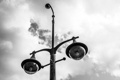 Low angle view of street light and cctv camera against sky