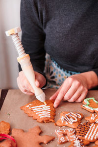 Midsection of woman preparing gingerbread cookies on table