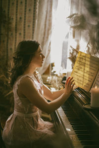 Side view of woman playing piano