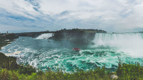 Scenic view of river against cloudy sky