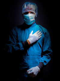 Midsection of person wearing hat against black background