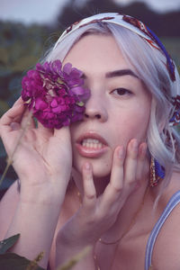 Close-up portrait of woman with pink flower