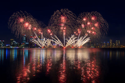 Firework display over river at night