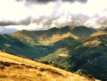 Scenic view of mountains against cloudy sky