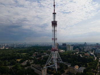 Aerial view of buildings in city against cloudy sky