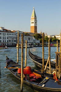 Gondolas moored on sea against church of san giorgio maggiore