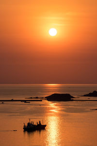 Scenic view of sea against dramatic sky during sunset