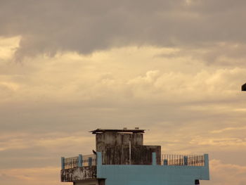 Houses against cloudy sky