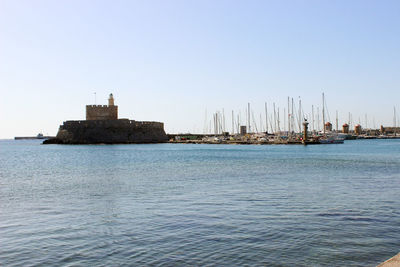 Sailboats in sea against clear sky