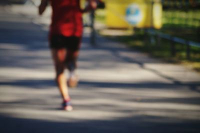 Low section of woman walking on road