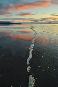 Close-up of sea against sky at sunset