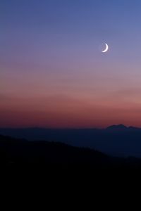 Scenic view of silhouette mountains against sky at night