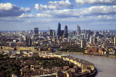 Aerial view of city buildings against cloudy sky