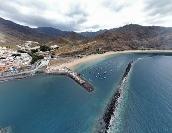 Aerial view of sea and mountains against sky