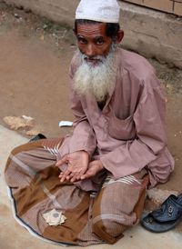 Beggar sitting on sidewalk