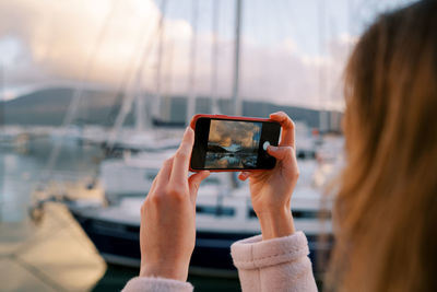 Cropped hand of woman using mobile phone