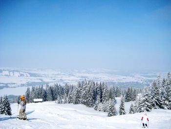 Rear view of people walking on snow covered landscape