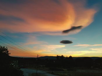 Silhouette of electricity pylon at sunset