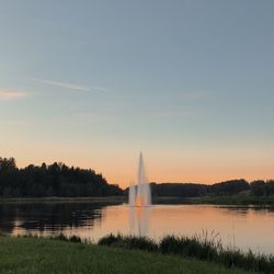 View of fountain in lake against sky during sunset