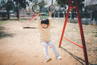 Full length of girl hanging at playground