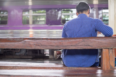 Rear view of man sitting outdoors