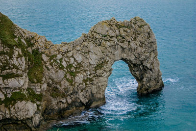 Rock formations by sea against sky