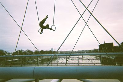 Low angle view of man jumping against sky