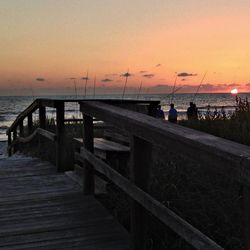 Pier on sea at sunset