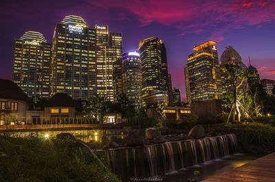 Illuminated buildings in city against sky at night