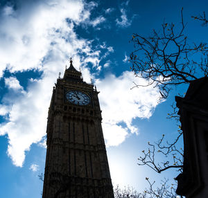 Low angle view of clock tower against cloudy sky