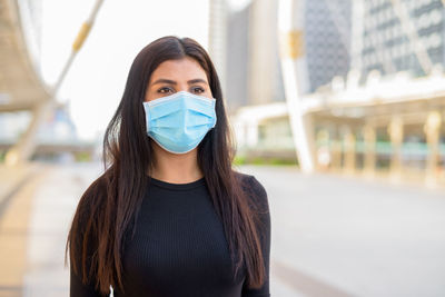 Portrait of beautiful young woman standing in city