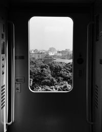 City and trees seen from train window