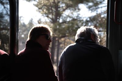 Rear view of man and woman looking through window