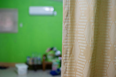 Close-up of curtain on table against window at home