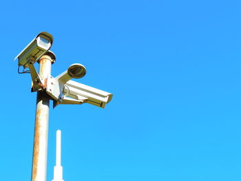 Low angle view of surveillance camera against sky