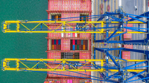 Directly above shot of crane and cargo container by lake