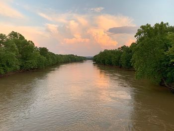 Scenic view of river against sky at sunset