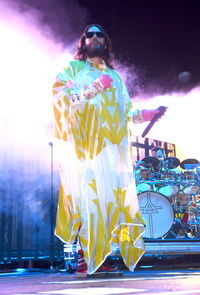 Rear view of woman with umbrella standing at night