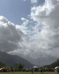 Group of people on mountain road against sky