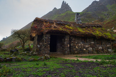 Old abandoned house on mountain against sky