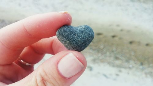 Close-up of human hand holding sand