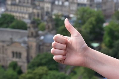 Cropped image of person hand against building