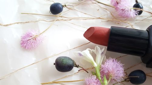 Close-up lipstick and flowers on table